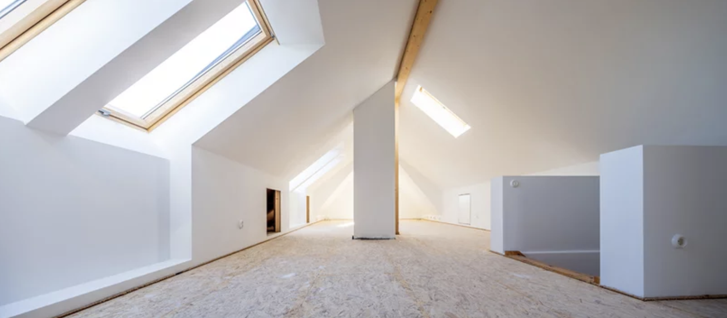 Dachgeschoss mit sichtbaren Holzbalken und Dachfenstern